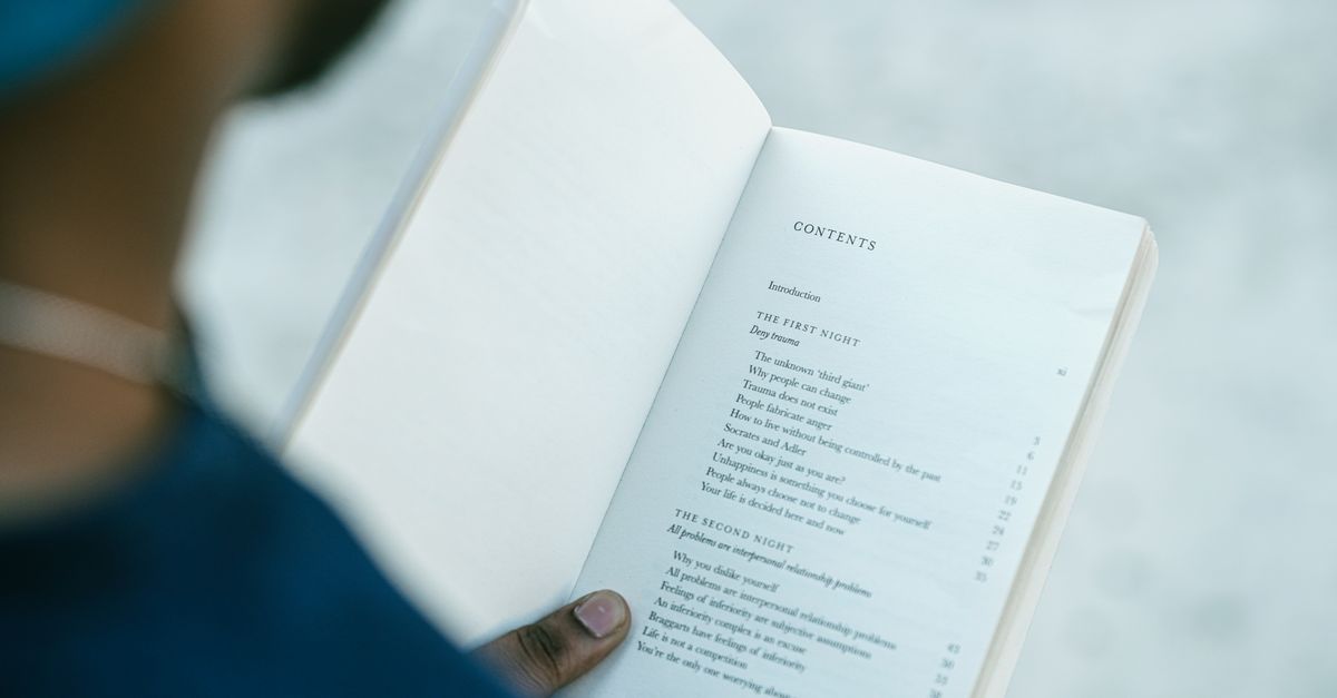 Un lecteur ouvre un livre à la page du sommaire et parcourt les entrées