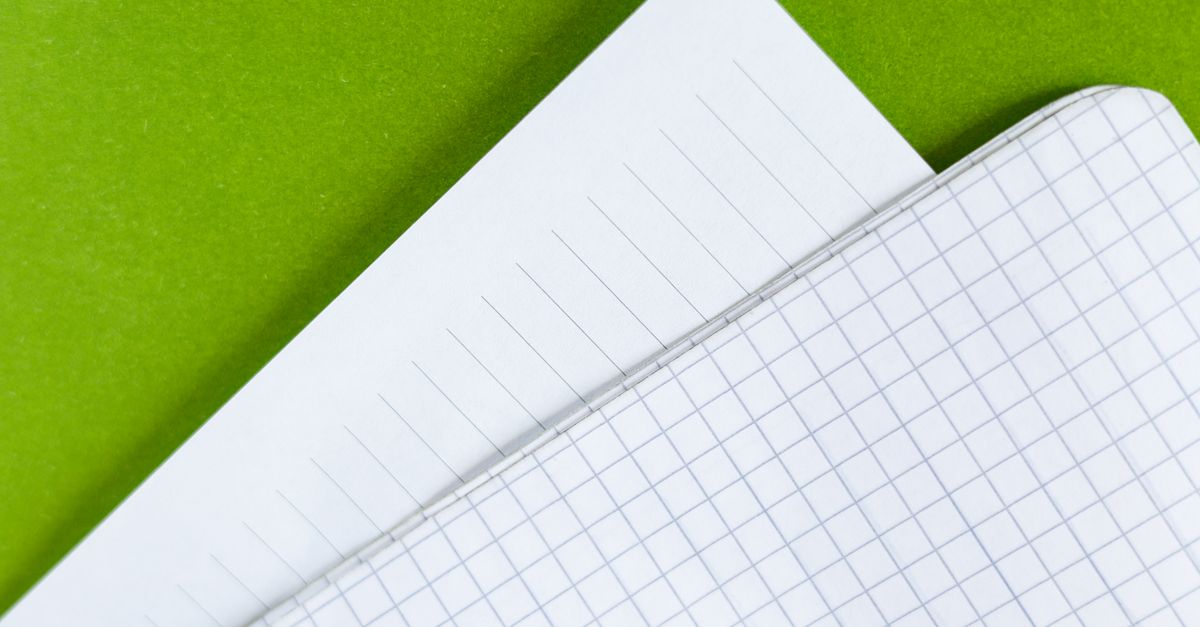 Des feuilles de papier lignées posées sur un plan de travail